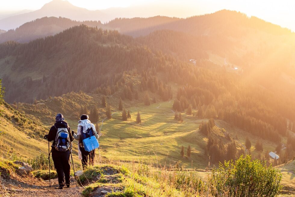 Seniorenpaar sitzt auf einer Holzbank in der Lüneburger Heide und genießt die Aussicht.